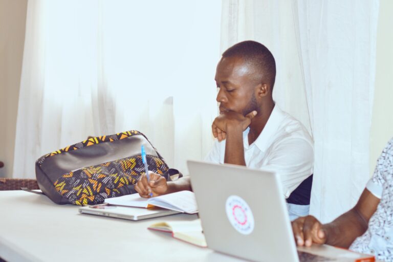 A man sitting at a table with his laptop.