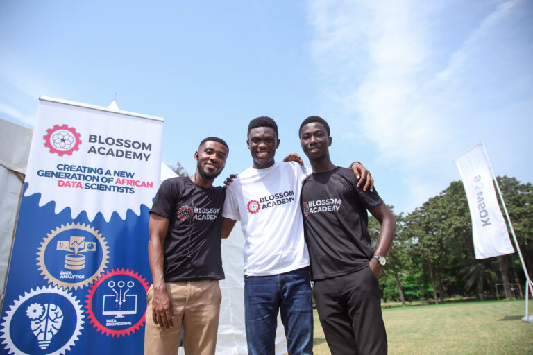 Three men standing in front of a sign.