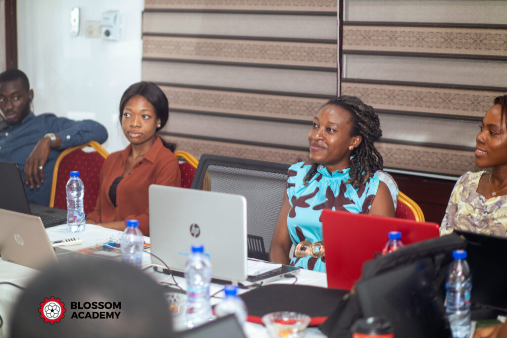 Two women sitting at a table with laptops.